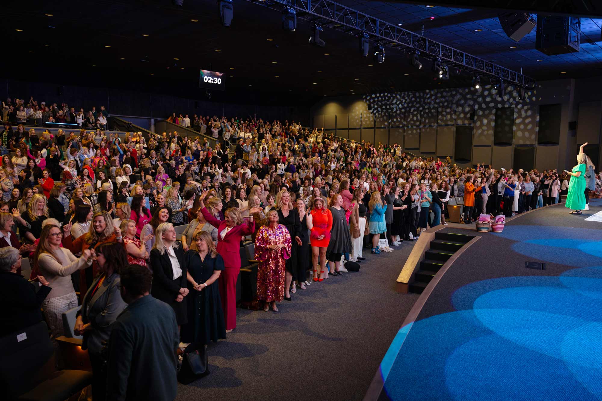 A full auditorium of guests standing and cheering